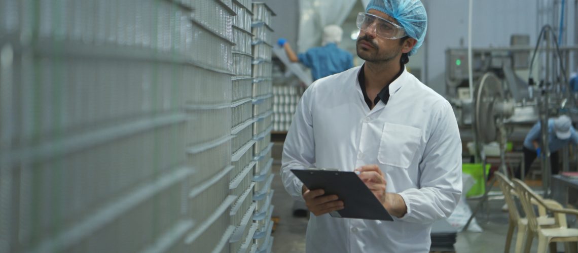 Exporter conducting supplier audit by checking temperature and hygiene of produce in cold storage.